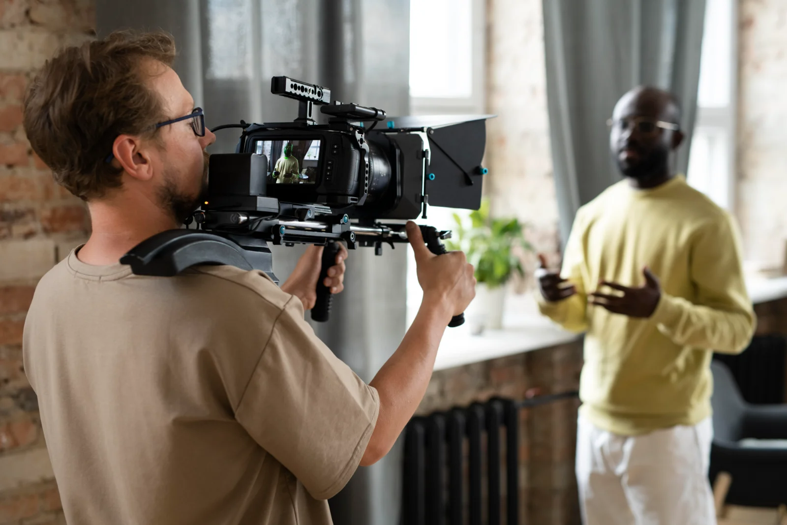 Cinematographer filming a scene with a shoulder-mounted cinema camera