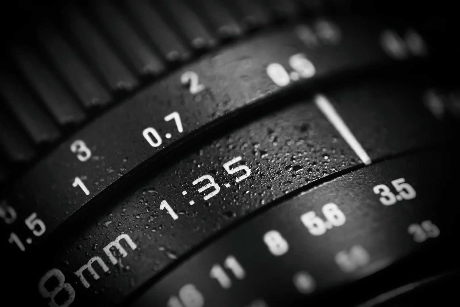 Close-up of a camera lens focus and aperture markings