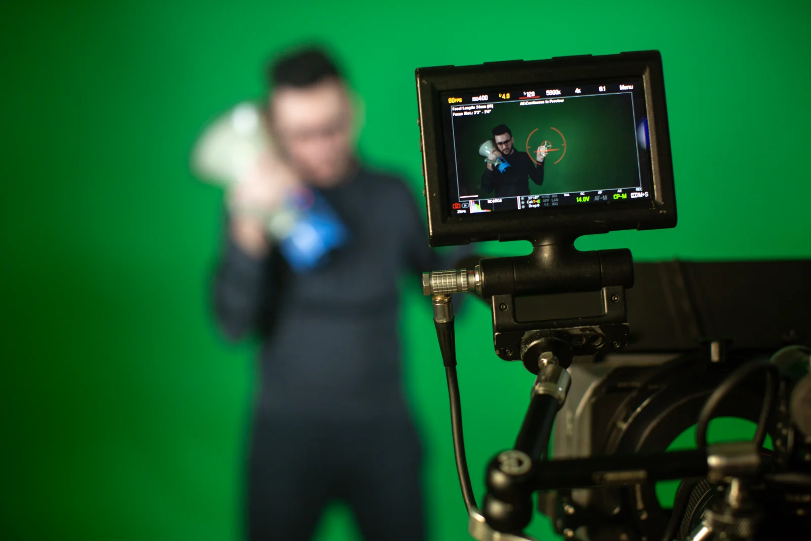 Camera operator framing a person against a green screen