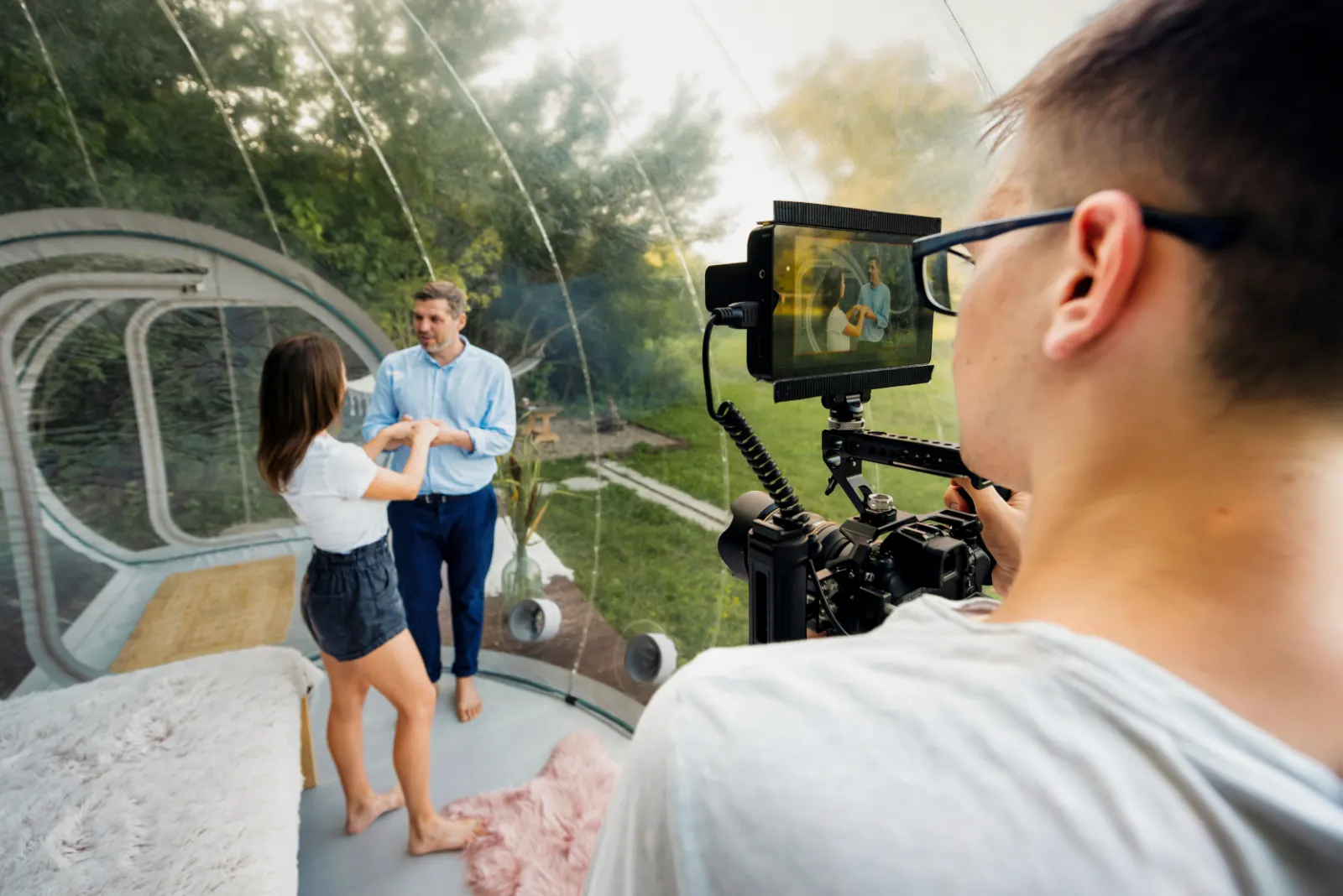 Videographer filming a couple with a rigged camera and monitor